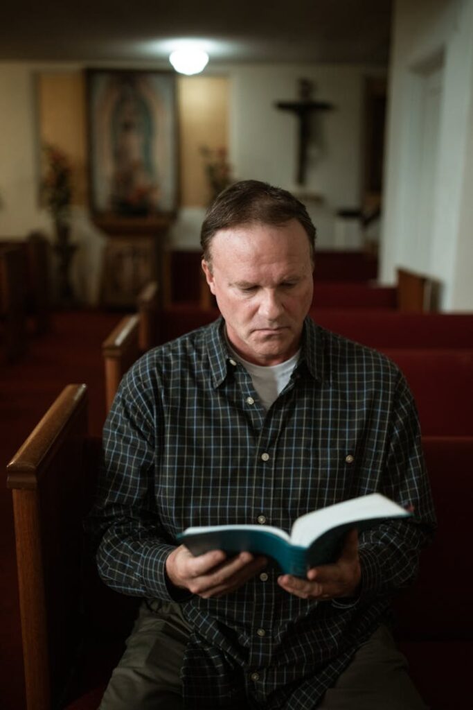 pexels-photo-5875270 A contemplative adult man reads a Bible in peaceful church interior.